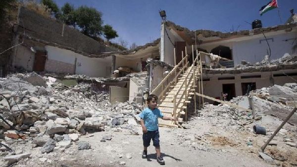 A Palestinian boy walks near the rubble of his family's destroyed house after Israeli bulldozers razed it down the previous day in the east Jerusalem neighborhood of Jabal Mukabbir in May. AFP Photo