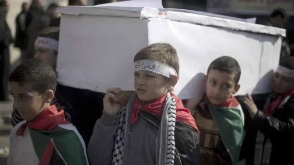 Palestinian children carry a fake coffin as they take part in a sit-in on January 4, 2014 in Gaza city in solidarity with Palestinian children at Yarmouk refugee camp in Syria. (AFP)