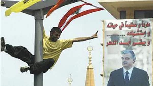 لبناني يشير بعلامة النصر امام جدارية للراحل الحريري