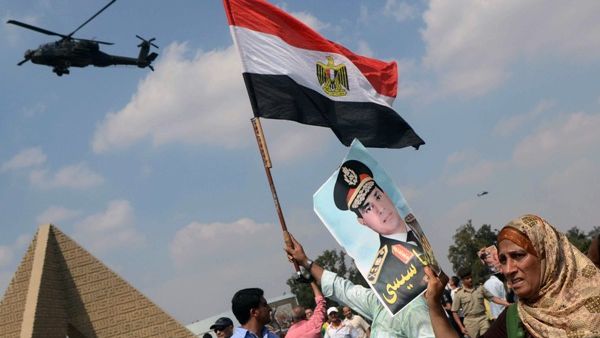 Egyptians waving the national flag and a portrait of Egyptian Defence Minister and Military Chief General Abdel Fattah al-Sisi in the district of Giza, on the outskirts of Cairo, on September 20, 2013. (AFP)