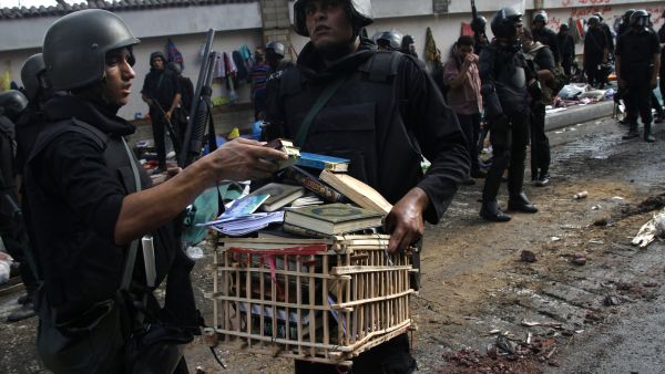 Egyptian police forces remove a crate filled with copies of the Koran and religious books after moving in to disperse supporters of Egypt's ousted president Mohamed Morsi (AFP/MOHAMMED ABDEL MONEIM)