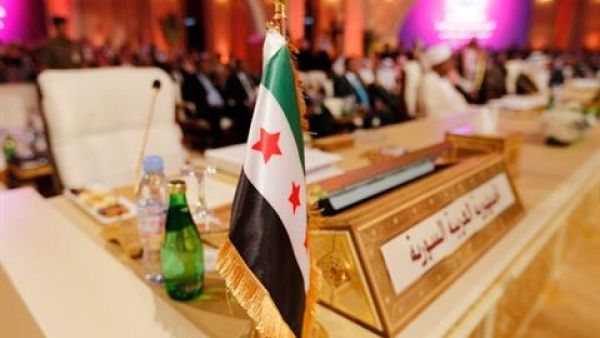 The flag of the Syrian opposition is shown at the seat of the delegation representing Syria at the Arab League summit in Doha in March. Image courtesy of The Daily Star
