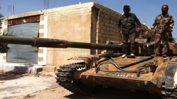 Syrian army soldiers standing on an army tank in the village of Buweida, north of Qusayr, in Syria's central Homs province on Friday. AFP photo