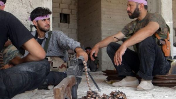 Rebel fighters sit in the ruins of a building in Aleppo earlier this week. Assad's army is making moves on the northern province, a rebel bastion. AFP/Shams photo