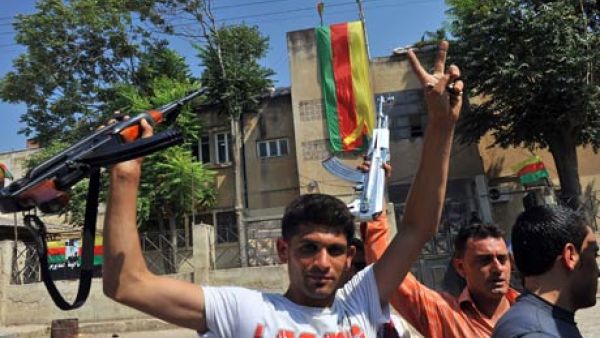 Syrian Kurds hold their rifles, as they flash the sign for victory, in the Kurdish town of Jinderes, near the northern Syrian city of Aleppo. (Photograph: Bulent Kilic/AFP/Getty Images)