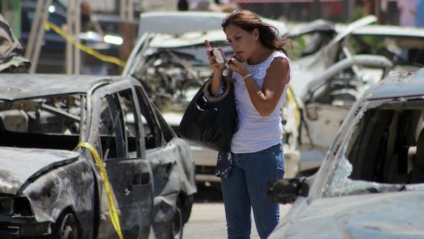 A woman adjusts her makeup amidst the wreckage following August's car bombs in Tripoli. (AFP/File)