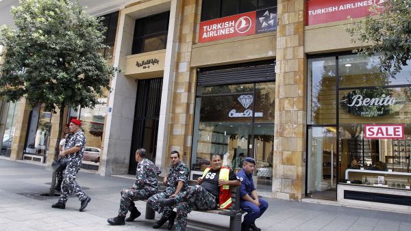Members of the Internal security forces sit outside the Turkish Airlines offices in downtown Beirut (AFP/JOSEPH EID)
