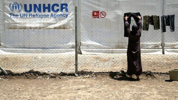 A woman put clothes to dry on a line at a Syrian refugee camp. AFP Photo
