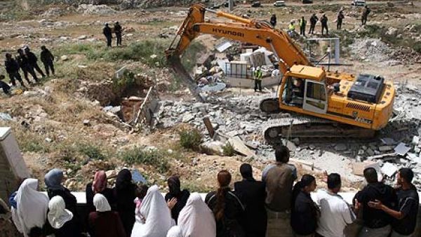 Palestinians watch an Israeli excavator destroying a Palestinian house in a village in the West Bank. (Photograph: Ahmad Gharabli/AFP/Getty images)
