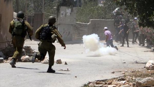 Palestinian demonstrators run for cover during clashes with Israeli troops following a protest against the expropriation of Palestinian land by Israel in the village of Kfar Qaddum near Nablus in the occupied West Bank on August 2, 2013. (AFP)