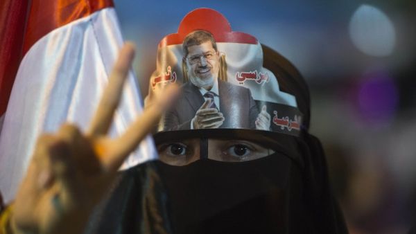 A female supporter puts Egypt's deposed president Mohamed Morsi portrait on her head during sit in outside Rabaa al-Adawiya mosque in Cairo on August 1, 2013. (AFP)