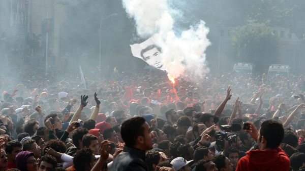 Egyptian fans of Al-Ahly football club wave a flag bearing the portrait of a victim of a football riot as they celebrate outside the club's headquarters in Cairo on Saturday. (AFP)