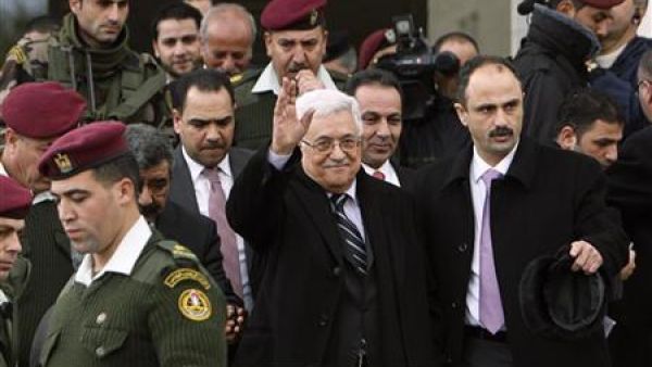 عباس (في الوسط) يلوح عقب حضوره احتفالا في رام الله بالضفة الغربية يوم الثلاثا
