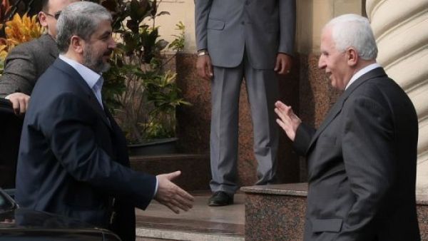 القيادي في فتح عزام الاحمد (يمين) مصافحا القيادي في حماس خالد مشعل في القاهرة
