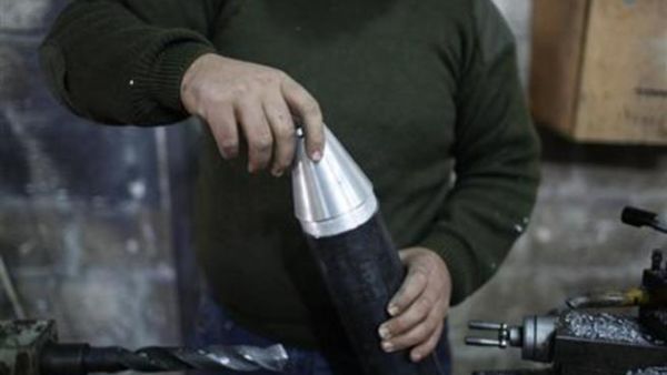 مقاتل يعمل في ورشة لتصنيع قذائف صاروخية في ورشة بحلب
