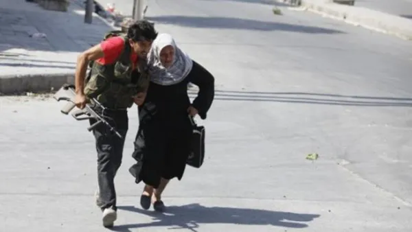 ارشيف/ مقاتل في حلب يساعد امراة على عبور الشارع