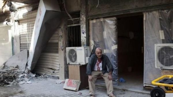 سوري يجلس بعد اصابته قرب مستشفى دار الشفاء في حلب
