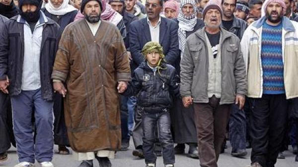 رجال يشاركون في جنازة شخص قتل بنيران الجيش السوري في منطقة القصير
