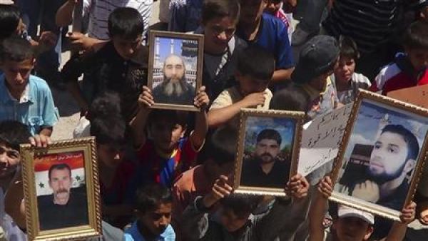 متظاهرون يحملون صورا لاشخاص يقولون انهم قتلوا على يد القوات الموالية للرئيس السوري بشار الاسد في سرمين قرب ادلب
