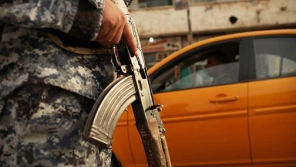 شرطي عراقي يراقب سيارات عند حاجز في بغداد