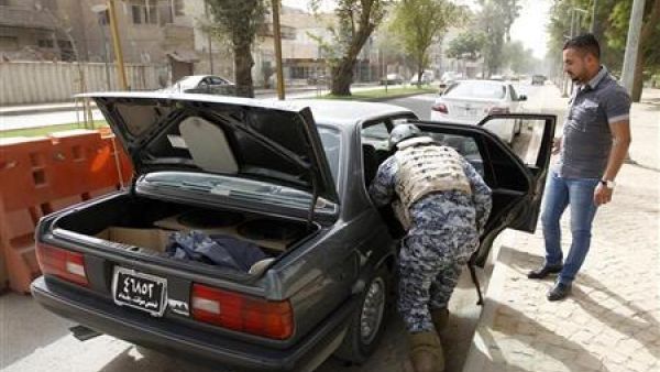 شرطي عراقي يفتش سيارة عند نقطة تفتيش في شارع أبونواس ببغداد
