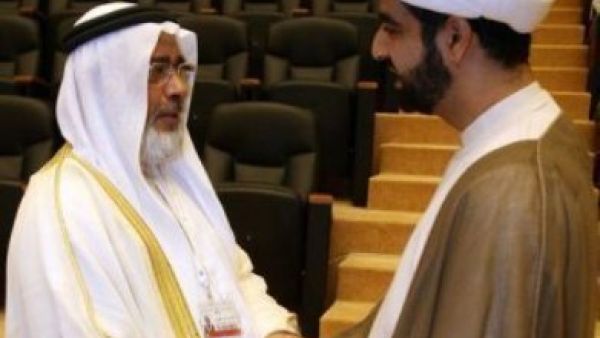 رئيس مجلس النواب البحريني خليفة الظهراني (يسار) مصافحا رجل دين شيعي في افتتاح الحوار 
