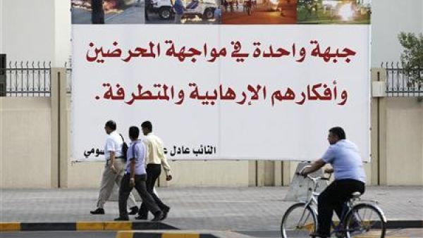 رجال يمرون امام لافتة نصبها احد نواب البرلمان في المنامة