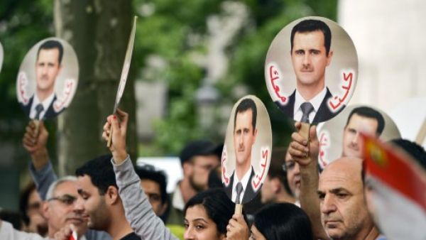  Demonstrators raise portraits of Syrian President Bashar Assad on September 8, 2013 in Brussels to protest against a potential military strike against Syria. (AFP)
