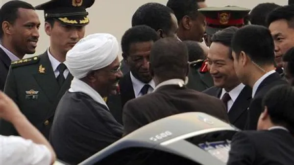 الرئيس السوداني عمر البشير (الثالث من جهة اليسار) يصافح المسؤولين الصينيين لدى وصوله مطار بكين الدولي يوم الثلاثاء.