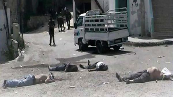 صورة التقطها مواطن صحفي تظهر جنودا من قوات الاسد يقفون قرب جثث قتلى في البيضا
