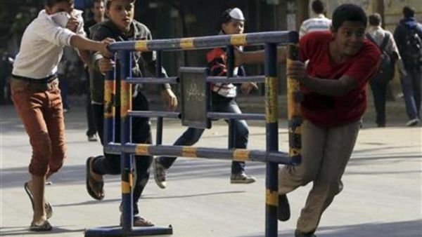 شبان يحركون حواجز خاصة بشرطة المرور أثناء اشتباك بين محتجين والشرطة في شارع محمد محمود قرب مبنى وزارة الداخلية بالقاهرة
