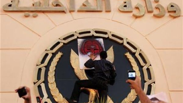محتج يلصق رسما على شعار وزارة الداخلية خارج مبنى الوزارة بالقاهرة 
