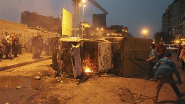 اشخاص يتجمعون بالقرب من حافلة للشرطة بعدما اضرم متظاهرون مناهضون لمرسي النار فيها في ميدان التحرير 
