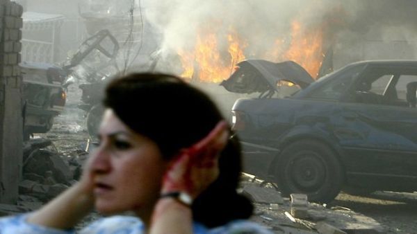 A woman holds her ears while fleeing one of the many car bomb atacks that have targeted Middle East countries over the past year (AFP)