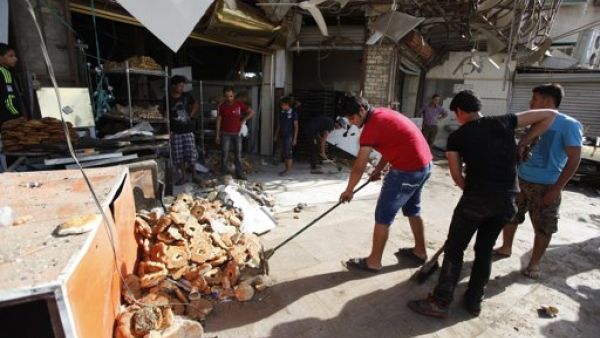 سكان يزيلون حطاما خلفه تفجير في مدينة الصدر في بغداد