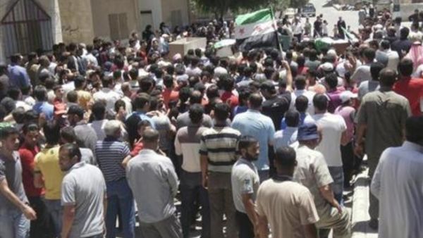 سكان يحملون نعوش اشخاص يقول محتجون انهم قتلوا جراء قصف قوات موالية للرئيس السوري بشار الاسد خلال جنازتهم في درعا يوم السبت
