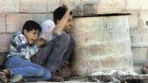 لقطة من الفيديو تظهر الشهيد محمد الدرة بجوار والده اثناء احتمائهما من الرصاص