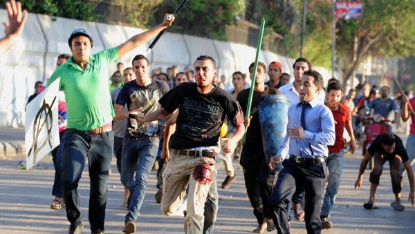 Pro-army supporters chase a bloodied pro-Morsi activist (center) in Cairo on July 22. (AFP / FAYEZ NURELDINE)