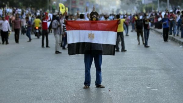 An Egyptian protestor holds his national flag during clashes between supporters of the Muslim Brotherhood and Egypt's ousted president Mohamed Morsi and security forces, in Cairo, on August 30, 2013. (AFP)