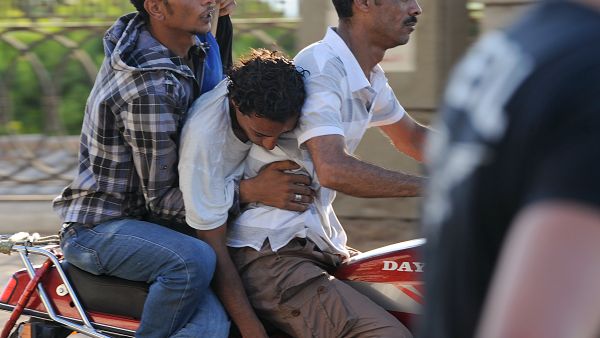 Army supporters evacuate an injured man after clashes with Morsi supporters on July 22. (AFP / FAYEZ NURELDINE)