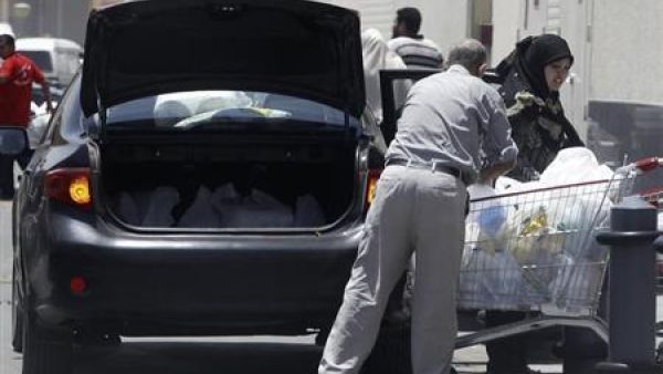 أسرة مصرية تضع مشترواتها من متجر للبقالة في الصندوق الخلفي للسيارة بالقاهرة
