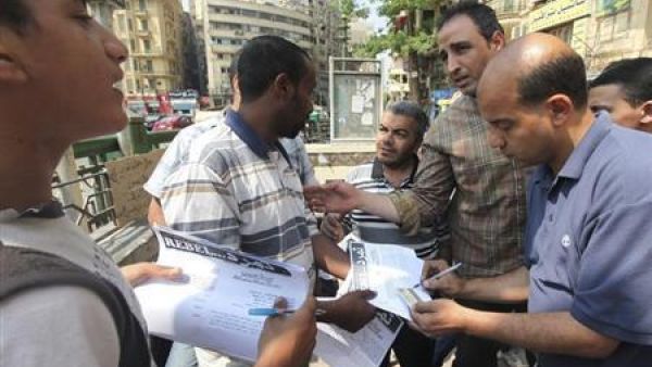 اعضاء من حملة تمرد يجمعون توقيعات مواطنين في ميدان التحرير بوسط القاهرة
