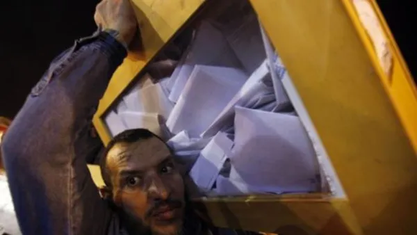 موظف في انتخابات مصر يحمل صندوق اقتراع تمهيدا للفرز