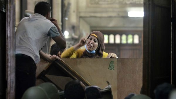 An Egyptian woman talks to policemen from the inside of Cairo's Al-Fath mosque (AFP/MOHAMED EL-SHAHED)