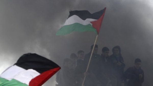 
فلسطينيون يرفعون اعلاما وطنية خلال تظاهرة في يوم الارض في بيت حانون