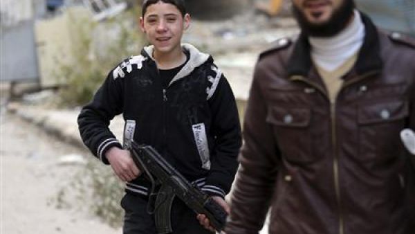 صبي من الجيش السوري الحر يحمل بندقية آلية في دمشق 
