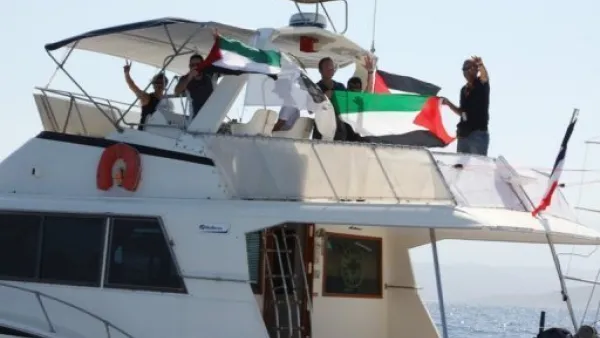 ناشطون يلوحون من على متن سفينة الكرامة عند ابحارها من كورسيكا السبت للانضمام الى اسطول الحرية المتوجه الى غزة 
