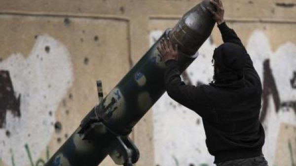 مقاتل من الجيش السوري الحر يجهز لاطلاق قذيفة مدفعية في دير الزور
