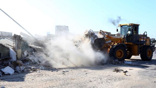 Workers tear into the wall of Moammar Gadhafi's compound in Tripoli on July 9, 2013. (source: AFP / MAHMUD TURKIA)
