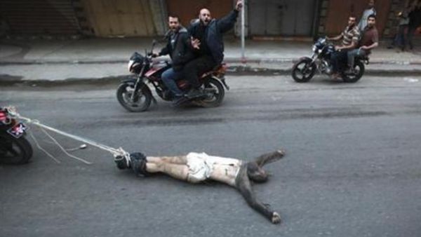 فلسطينيون على دراجة نارية يجرون على الأرض جثة أحد المشتبه في تعاونهم مع اسرائيل في شوارع غزة 

